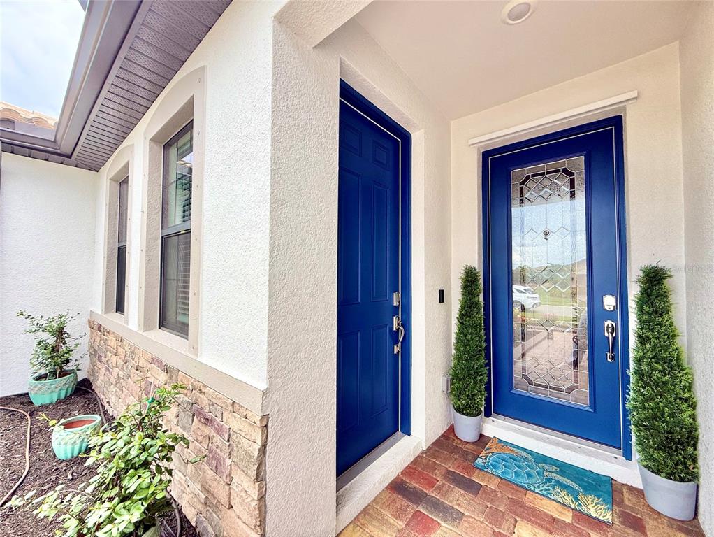 A front entryway features a blue front door with glass inlay and a matching side door — 20642 BENISSIMO DRIVE, VENICE, FL