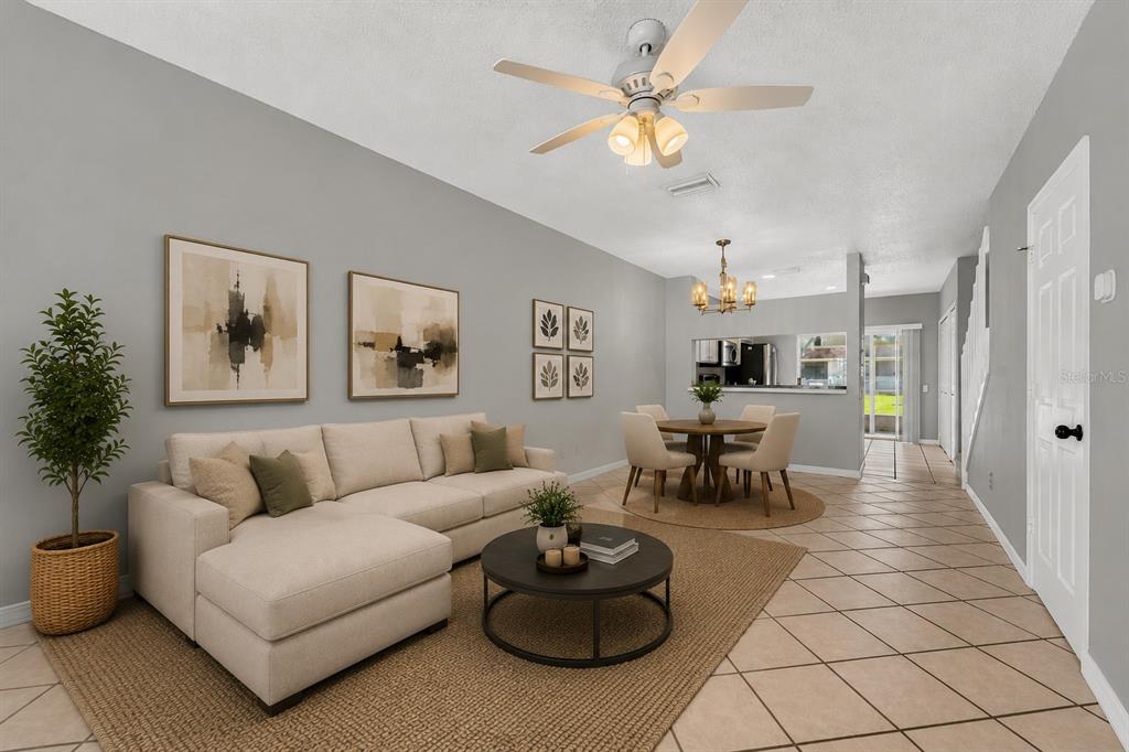 A living room and dining area with tile floors, a sectional sofa, and neutral walls — 17403 FLATWOODS KEY DRIVE, TAMPA, FL