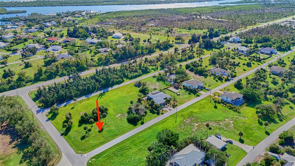 An aerial view shows a vacant, grassy corner lot marked by a red arrow — 141 POMPANO STREET, PLACIDA, FL