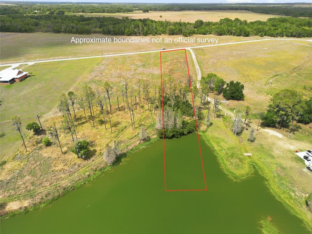 An aerial view shows a rectangular plot of land extending into a pond — TBD TIMBERS DRIVE, FORT MEADE, FL