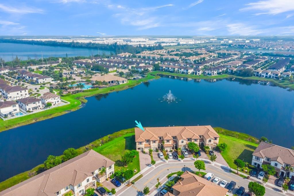 An aerial view shows a multi-unit residential building with a tiled roof beside a lake — 3401 W 94th Ter, Hialeah FL 33018-2079, HIALEAH, FL