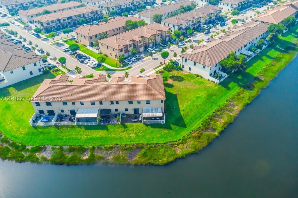 An aerial view shows a multi-unit townhouse complex situated next to a body of water — 3401 W 94th Ter, Hialeah FL 33018-2079, HIALEAH, FL