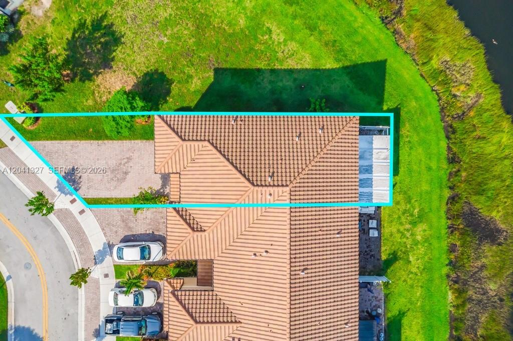 An aerial view shows the tiled roof of a house next to a grassy area — 3401 W 94th Ter, Hialeah FL 33018-2079, HIALEAH, FL