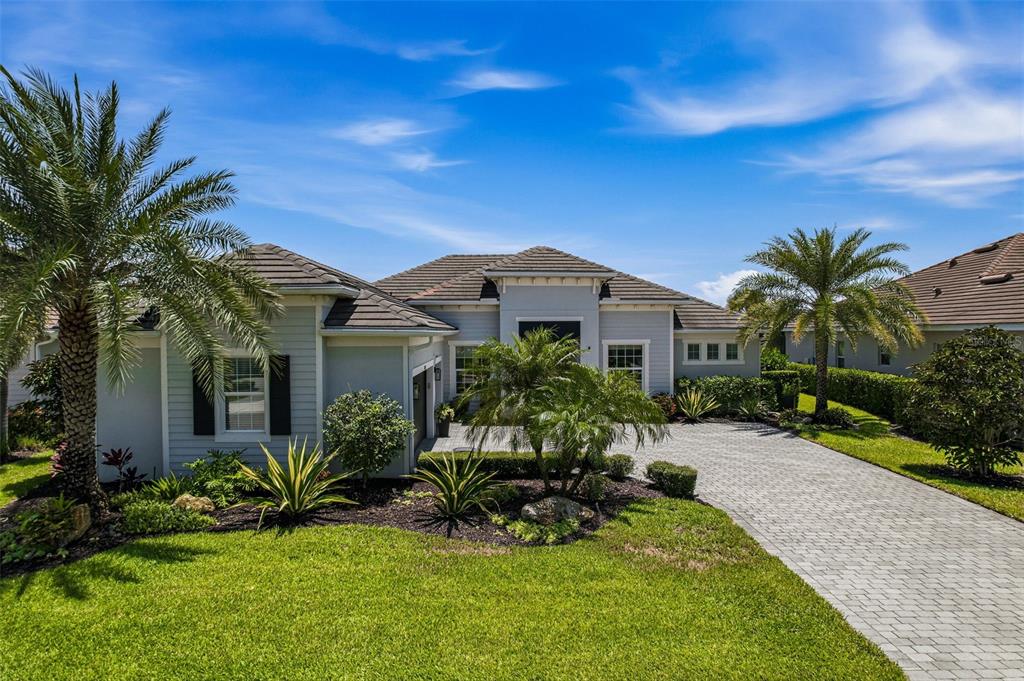 A single-story house with light gray siding, a tiled roof, and a paved driveway — 15967 TALON TERRACE, PUNTA GORDA, FL