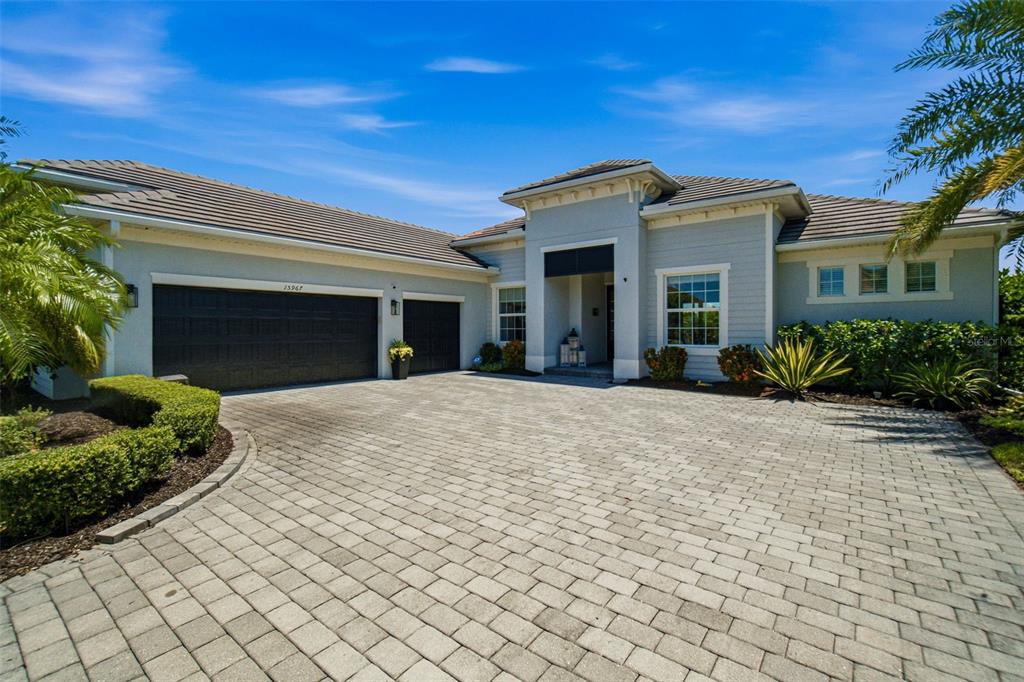 A single-story house with a paved driveway, a three-car garage, and a covered entryway — 15967 TALON TERRACE, PUNTA GORDA, FL