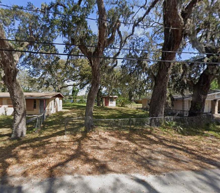 A grassy lot sits between two small houses under large, moss-covered oak trees — 529 FULTON STREET, DAYTONA BEACH, FL
