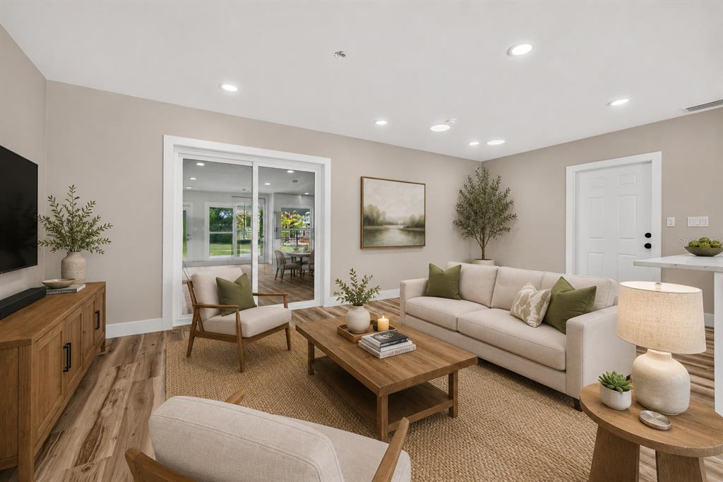 A living room features a beige sofa, two armchairs, a coffee table, and sliding glass doors — 1524 CARSON CIRCLE NE, ST PETERSBURG, FL