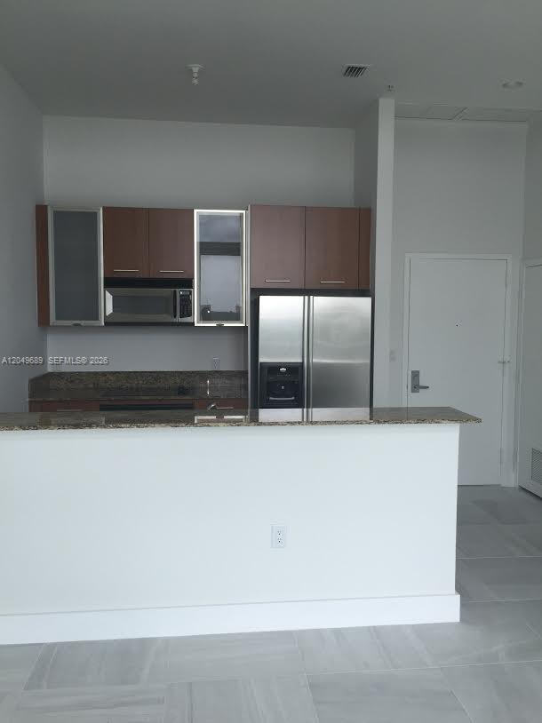 A kitchen features brown cabinets, stainless steel appliances, and a granite countertop island — 9066 SW 73rd Ct # 503, Miami FL 33156, MIAMI, FL