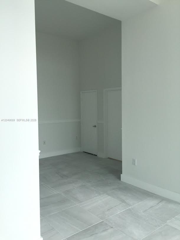 An interior view shows a room with light gray walls, white trim, and gray tile flooring — 9066 SW 73rd Ct # 503, Miami FL 33156, MIAMI, FL