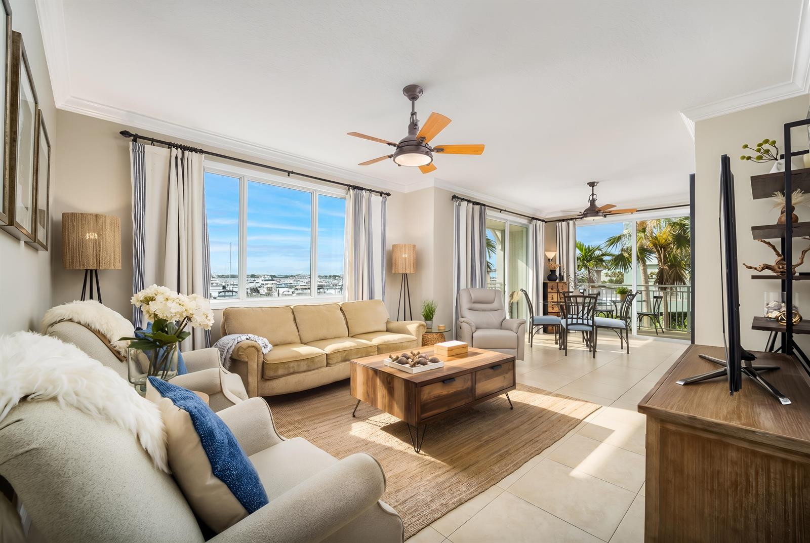 A living room with beige furniture, a wooden coffee table, and a view of boats — 875 NW Flagler Avenue # 203, Stuart FL 34994, STUART, FL