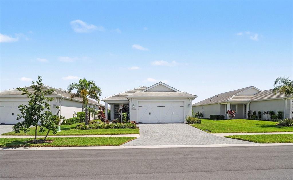 A single-story suburban house with a two-car garage and a paved driveway — 8144 STERNWAY ROAD, SARASOTA, FL