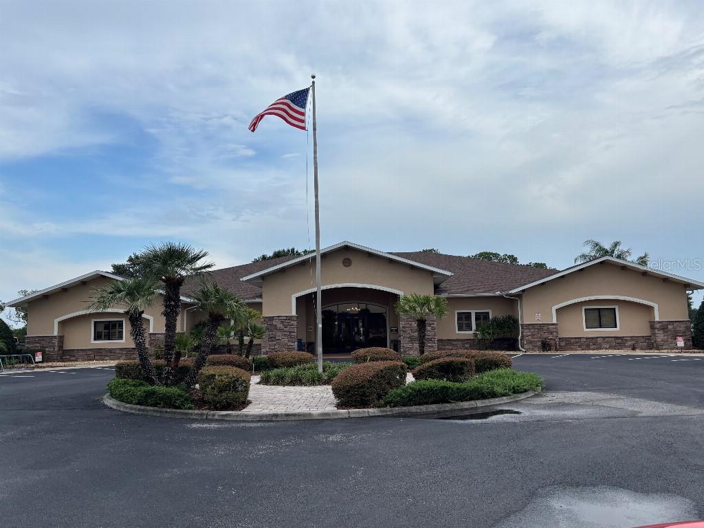 A single-story commercial building with a stone facade, a central entrance, and an American flag — 1098 MOTORCOACH DRIVE, POLK CITY, FL