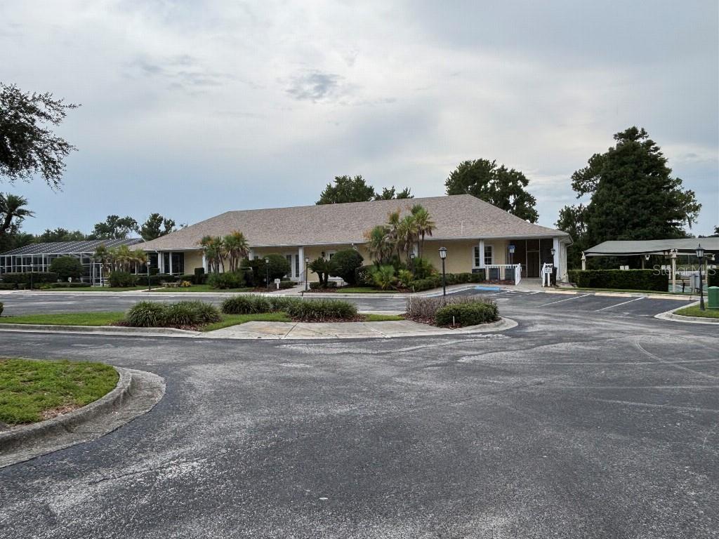 A single-story building with a light-colored exterior and a large parking lot in front — 1098 MOTORCOACH DRIVE, POLK CITY, FL