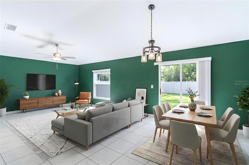 This open-concept living and dining room features green walls, tile flooring, and a sliding door — 1863 YELLOW TRAIL, LAKELAND, FL
