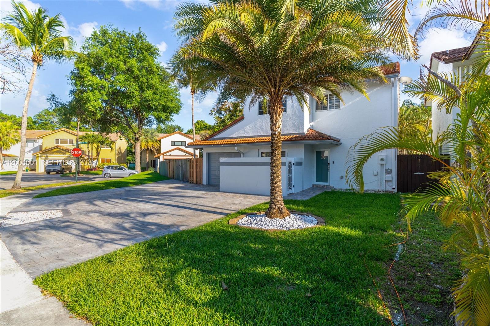A two-story white house with a paved driveway, a palm tree, and a green lawn — 15134 SW 94th Ter, Miami FL 33196, MIAMI, FL