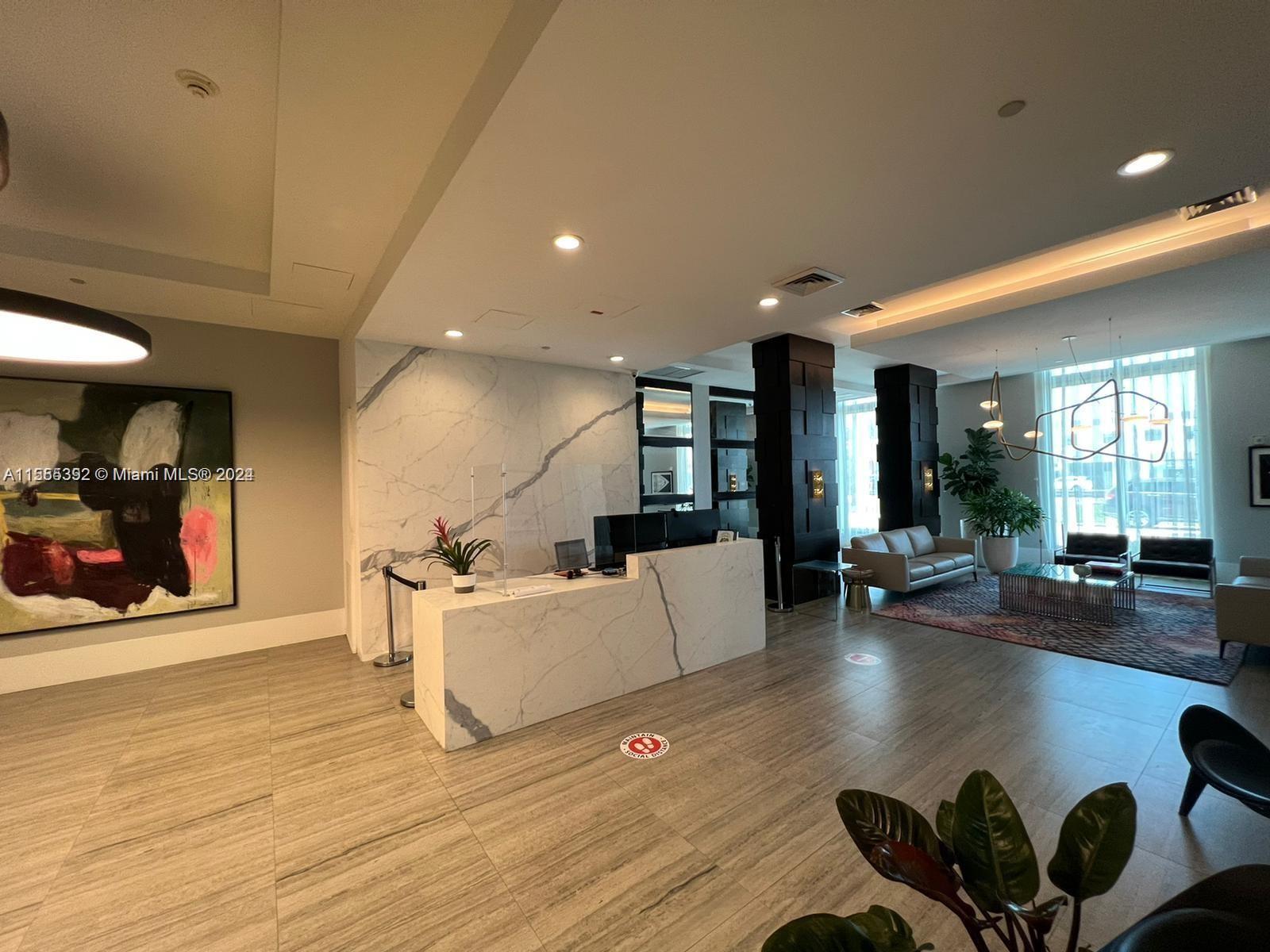 A modern lobby features a marble reception desk, tile flooring, and a seating area — 140 S Dixie Hwy # 521, Hollywood FL 33020, HOLLYWOOD, FL