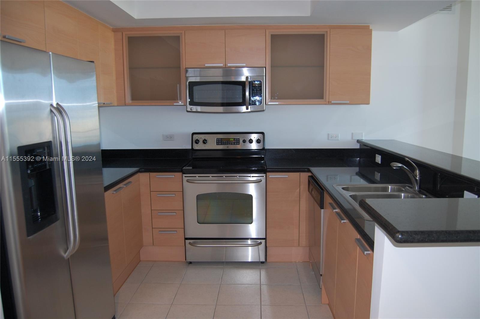 A kitchen features light wood cabinets, stainless steel appliances, and black granite countertops — 140 S Dixie Hwy # 521, Hollywood FL 33020, HOLLYWOOD, FL