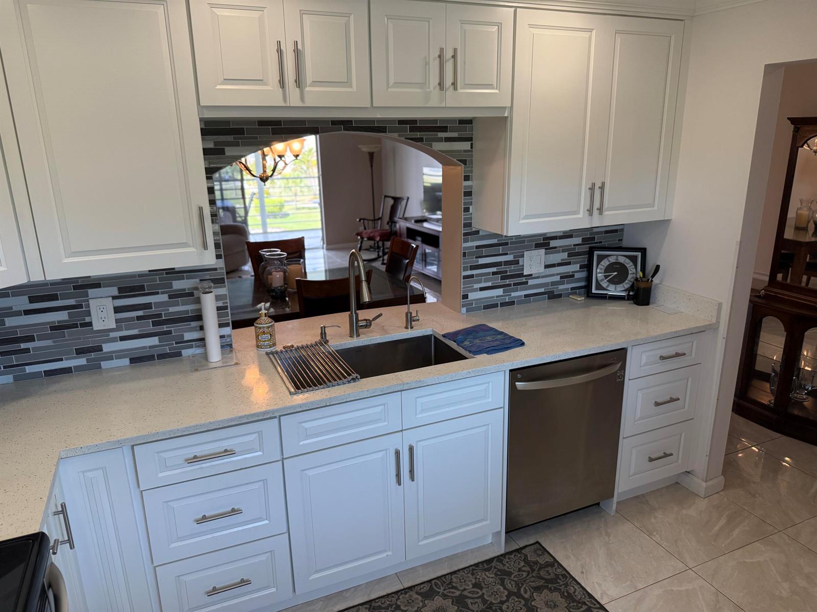 A kitchen features white cabinets, quartz countertops, a stainless steel sink, and a tiled backsplash — 1024 SE 5th Avenue # 308, Dania Beach FL 33004, DANIA BEACH, FL