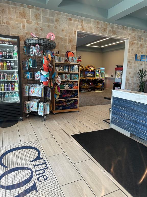 A retail area features a beverage cooler, merchandise racks, and an adjacent arcade room — 2861 SIMILE STREET, KISSIMMEE, FL