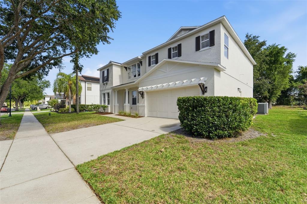 A two-story house with a white stucco exterior, a garage, and a front lawn — 10143 MALPAS POINT, ORLANDO, FL