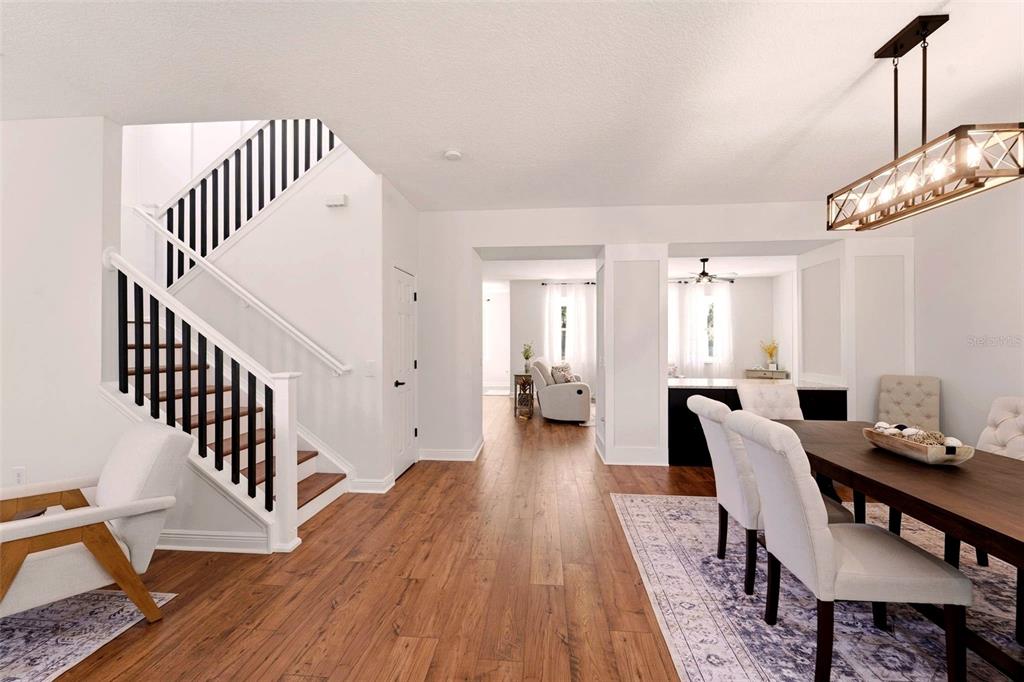 A dining area with a wooden table and stairs leading to an upper floor — 10143 MALPAS POINT, ORLANDO, FL