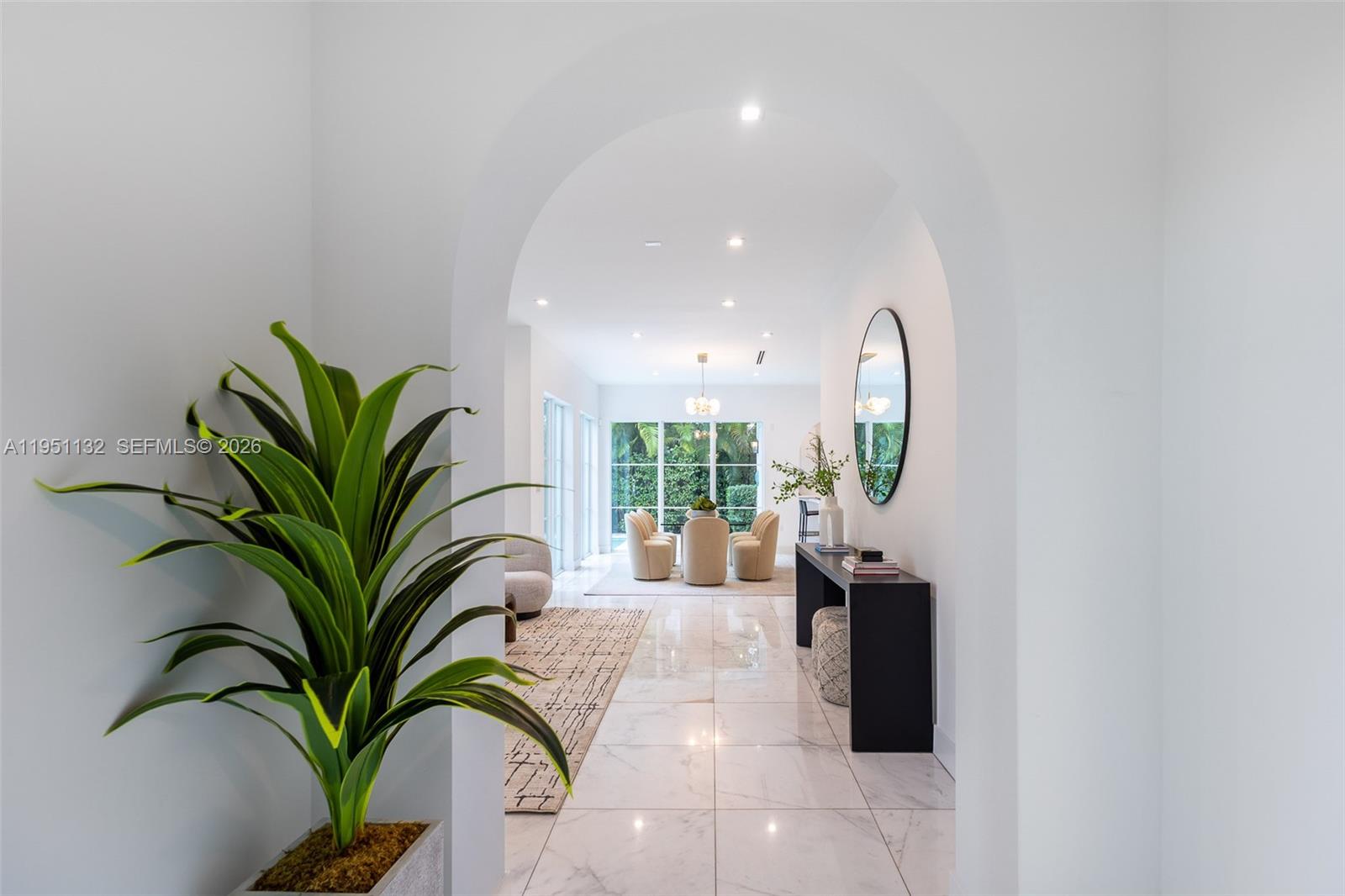 A bright hallway with an arched entryway leads to a dining area with marble floors — 315 Santander Ave # 315, Coral Gables FL 33134, CORAL GABLES, FL