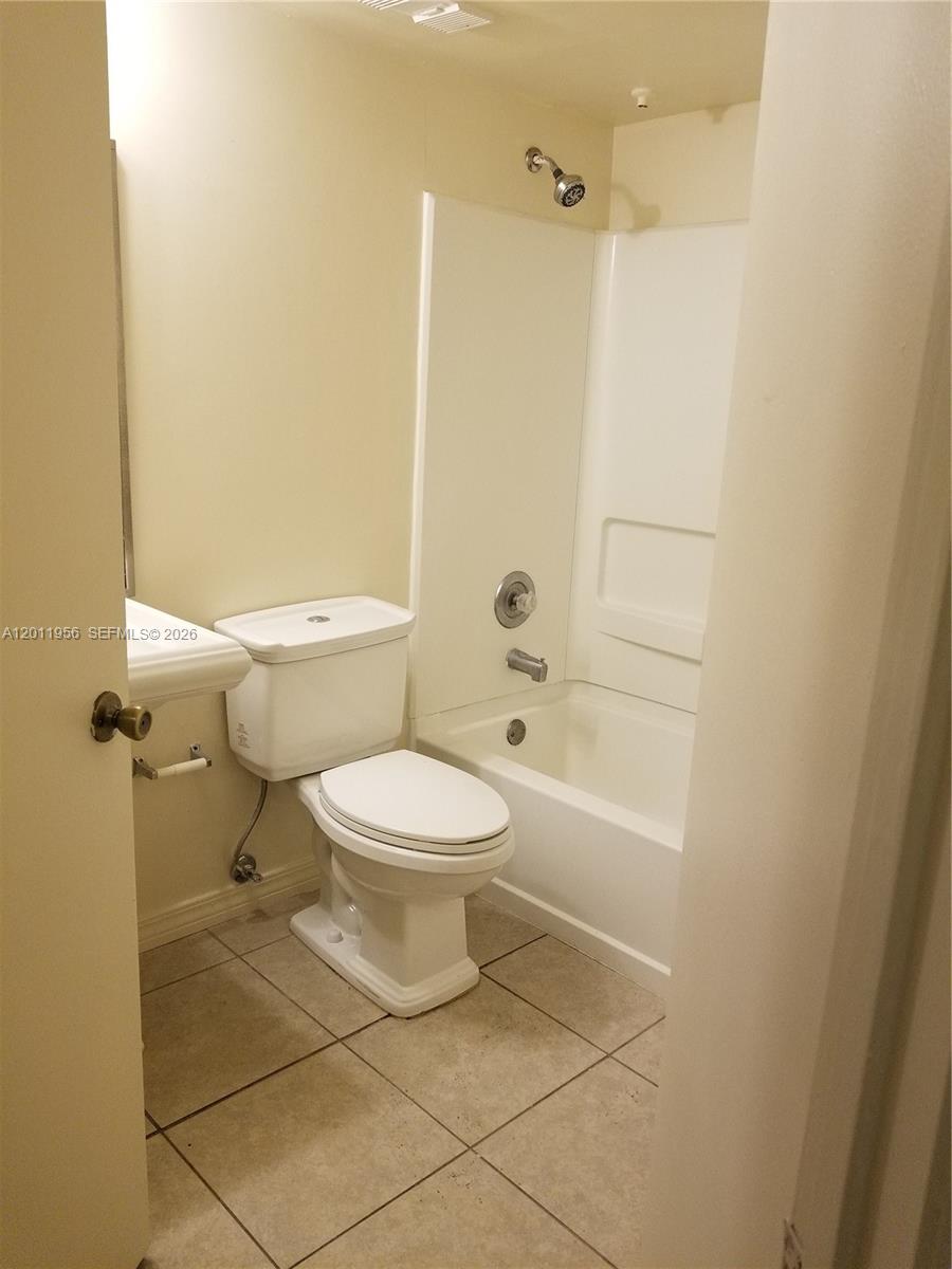 A bathroom features a white toilet, a pedestal sink, and a shower-tub combination — 15241 SW 80th St # 201, Miami FL 33193, MIAMI, FL