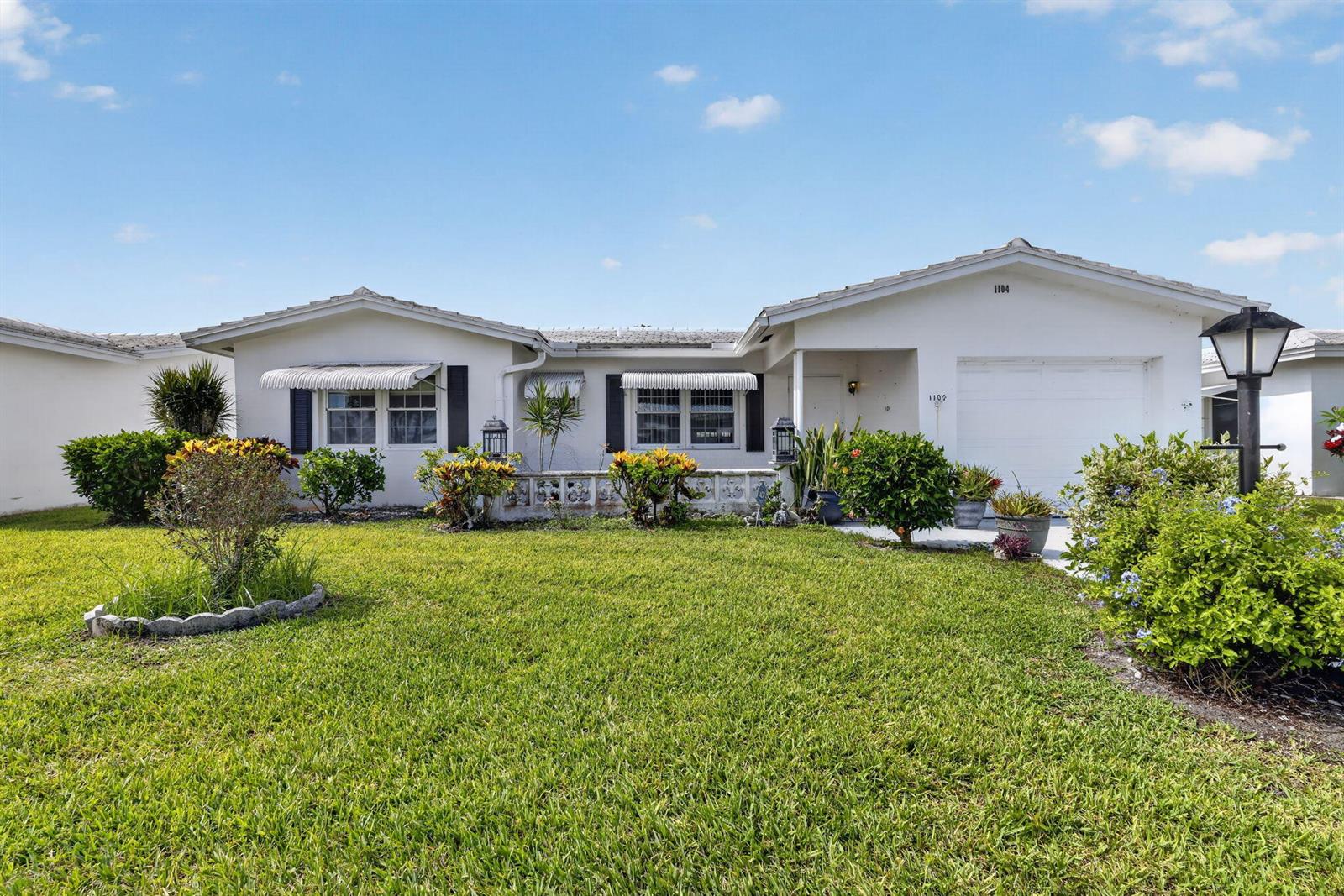 A single-story white house with a lawn, landscaping, and a one-car garage — 1104 W Ocean Avenue, Boynton Beach FL 33426, BOYNTON BEACH, FL