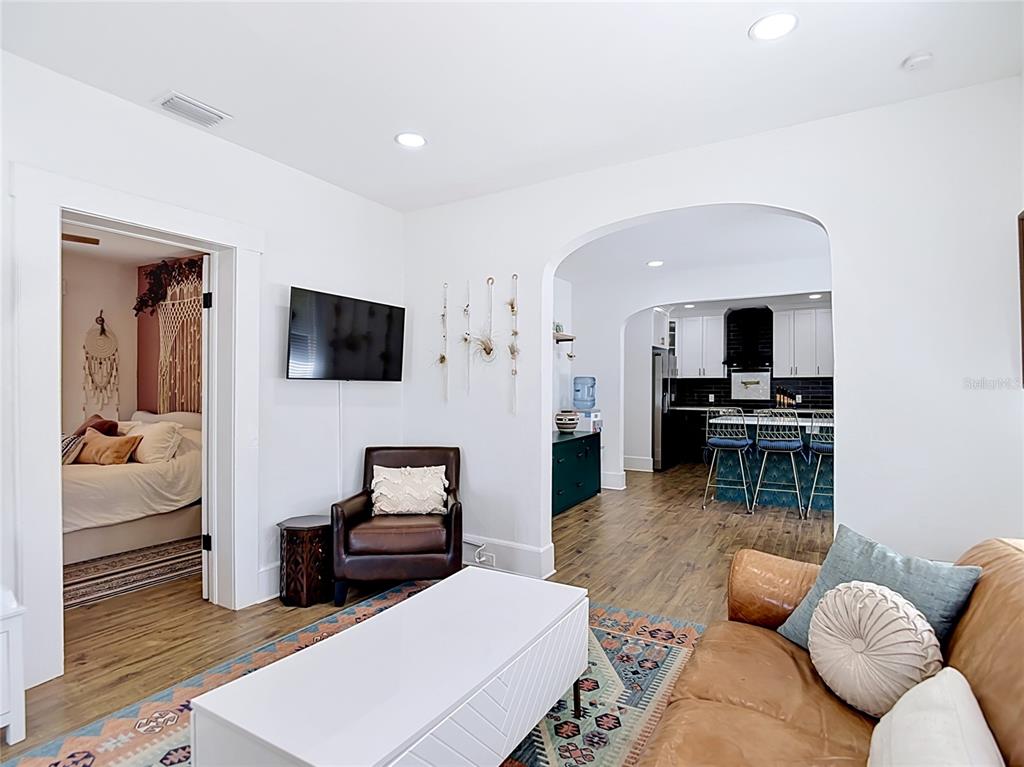 A living room with a leather armchair and sofa leads into a kitchen through an archway — 105 W ELM STREET, TAMPA, FL