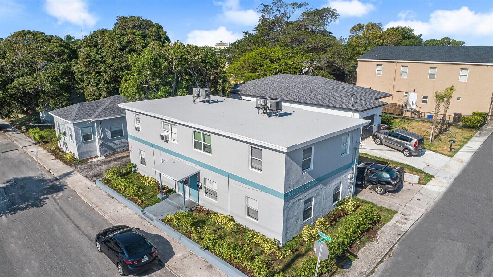 An aerial view shows a two-story gray apartment building with a flat roof and landscaping — 1913 Division Avenue, West Palm Beach FL 33407, WEST PALM BEACH, FL