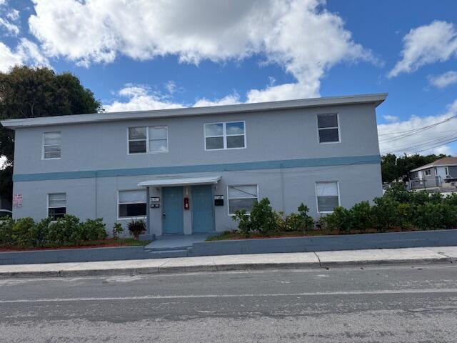 A two-story, light gray apartment building with blue trim and a central entrance — 1913 Division Avenue, West Palm Beach FL 33407, WEST PALM BEACH, FL