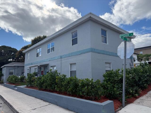 A two-story, light blue apartment building sits on a corner lot with landscaping — 1913 Division Avenue, West Palm Beach FL 33407, WEST PALM BEACH, FL