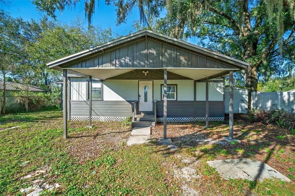 A single-story house with a covered front porch and gray siding stands on a lot — 2206 SHIRAH ROAD, AUBURNDALE, FL