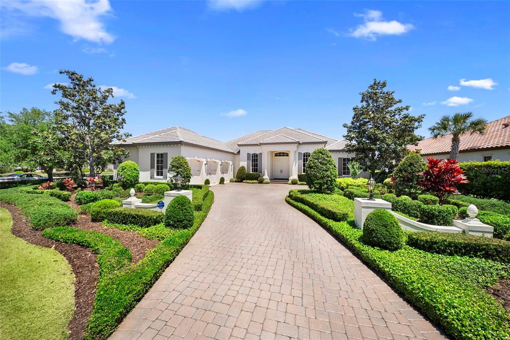 A single-story house with a paved driveway and manicured landscaping under a clear blue sky — 16204 DAYSAILOR TRAIL, LAKEWOOD RANCH, FL
