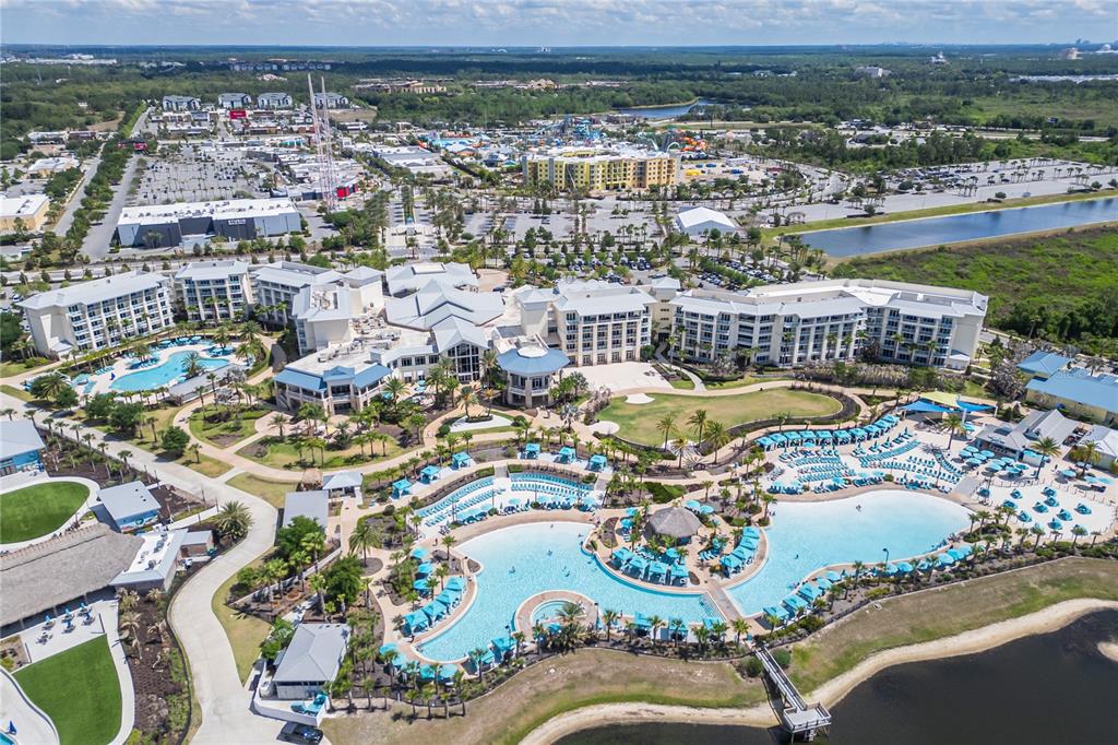 An aerial view shows a large resort hotel with multiple swimming pools and surrounding grounds — 2915 CASTAWAY LANE, KISSIMMEE, FL