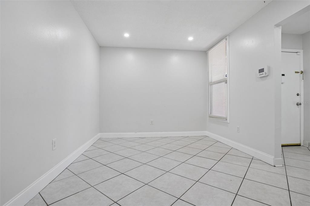 An empty room features light gray walls, white tile flooring laid diagonally, and a single window — 546 ORANGE DRIVE UNIT 13, ALTAMONTE SPRINGS, FL