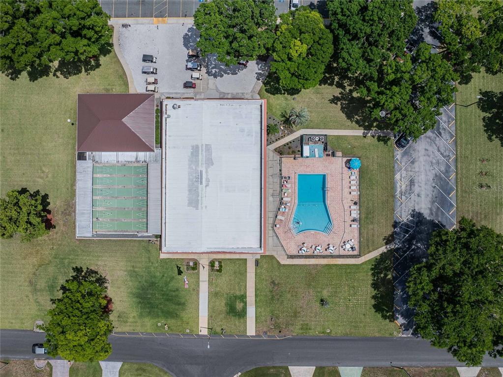 Aerial view of a building complex featuring a swimming pool, tennis court, and parking lots — 1610 REYNOLDS RD. UNIT 108, LAKELAND, FL