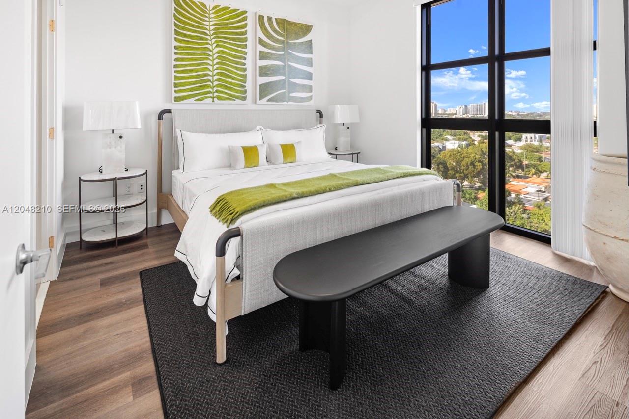A bedroom features a bed with green accents, a dark bench, and floor-to-ceiling windows — 2800 SW 27th Terrace # 0513, Miami FL 33133, MIAMI, FL