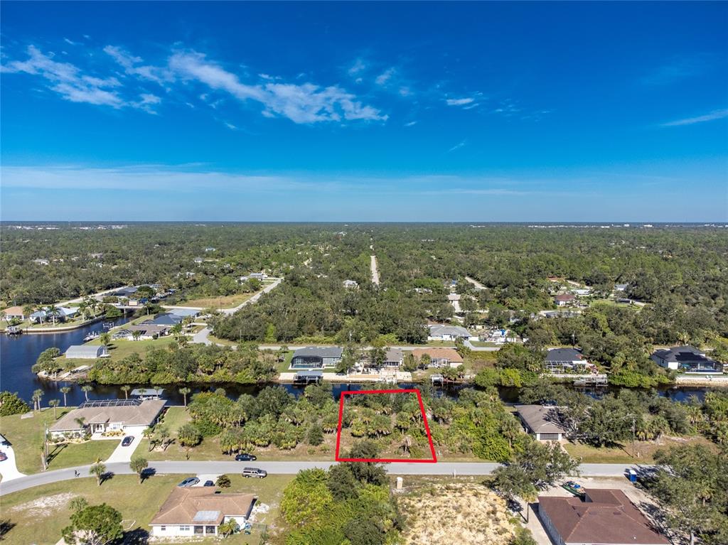 An aerial view shows a vacant, rectangular lot outlined in red near a canal — 17340 GULFSPRAY CIRCLE, PORT CHARLOTTE, FL