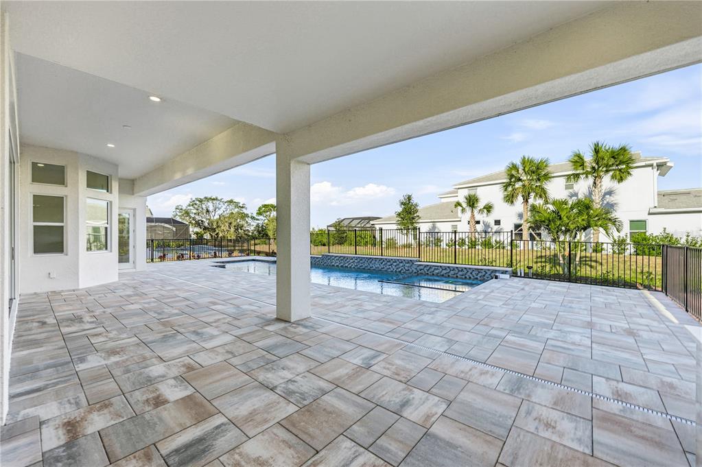 An aerial view of a house with a screened-in pool and a tiled roof — 8065 NEVIS RUN, BRADENTON, FL