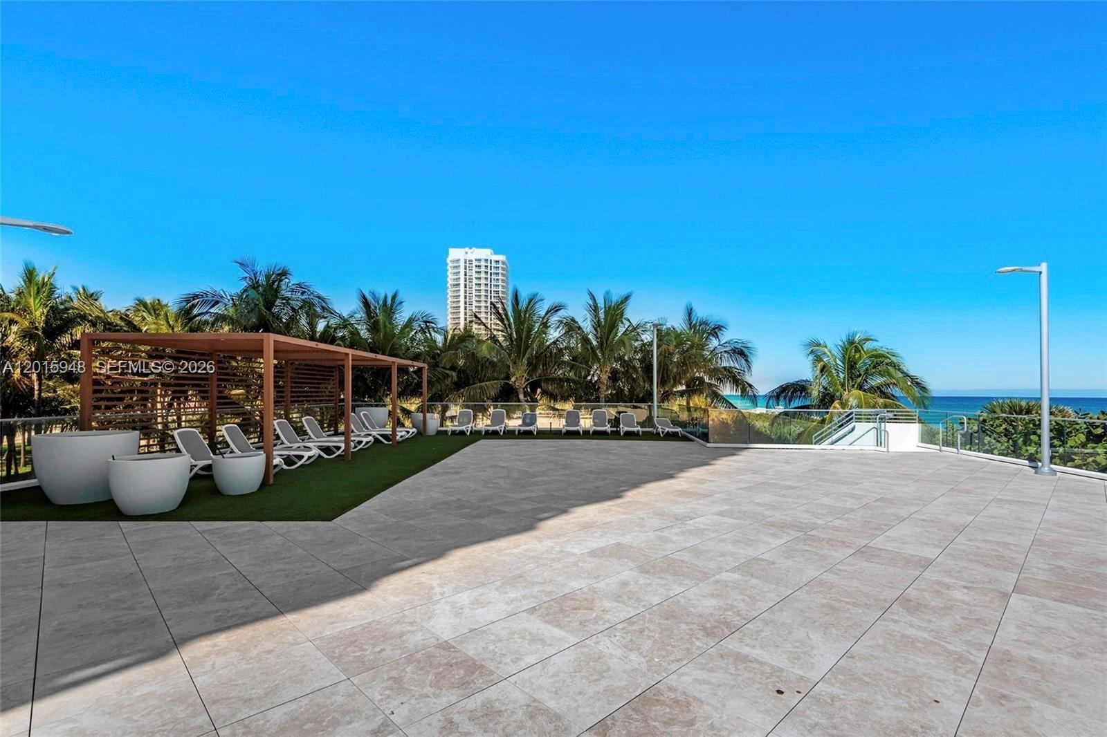 A spacious outdoor terrace features a wooden pergola, lounge chairs, and ocean views — 7135 Collins Ave # 1214, Miami Beach FL 33141, MIAMI BEACH, FL