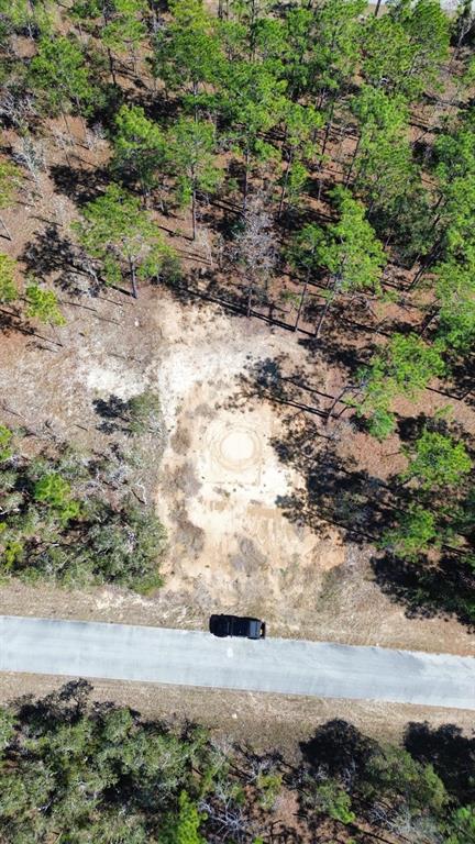 An aerial view shows a cleared sandy lot with a circular marking near a road — 24491 NW HEMLOCK AVENUE, DUNNELLON, FL