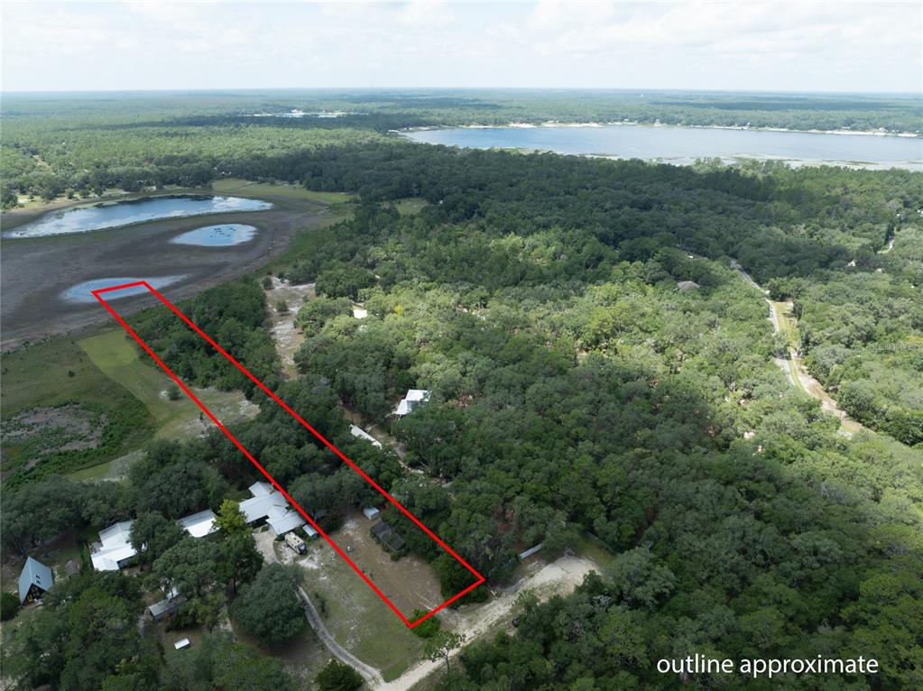 An aerial view shows a rectangular property outline extending toward a small lake — 111 2ND STREET, MELROSE, FL