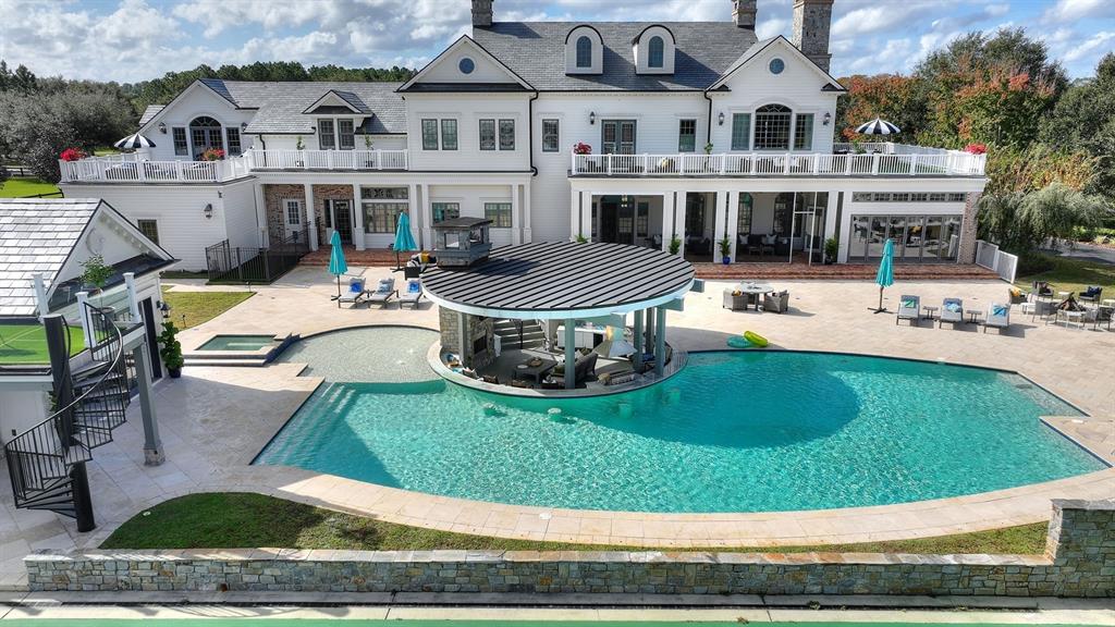 An aerial view of a large house with a pool, swim-up bar, and patio area — 3018 KINGFISHER POINT, CHULUOTA, FL