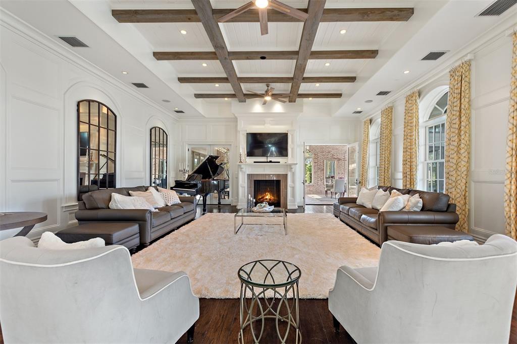 A spacious living room features a coffered ceiling, a fireplace, and two brown leather sofas — 3018 KINGFISHER POINT, CHULUOTA, FL