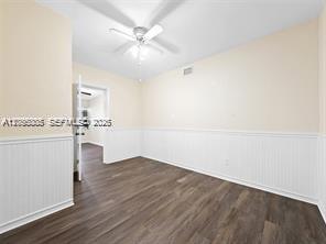 An empty room with wood-look flooring, white wainscoting, and a ceiling fan — 1311 N 19th Ave # 1, Hollywood FL 33020, HOLLYWOOD, FL