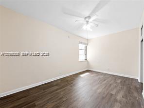 An empty bedroom features light-colored walls, a ceiling fan, and dark wood-look laminate flooring — 1311 N 19th Ave # 1, Hollywood FL 33020, HOLLYWOOD, FL