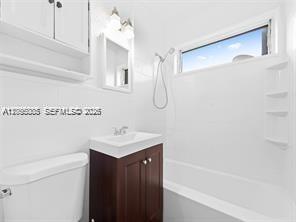A bathroom features a white toilet, a dark wood vanity, and a shower-tub combination — 1311 N 19th Ave # 1, Hollywood FL 33020, HOLLYWOOD, FL