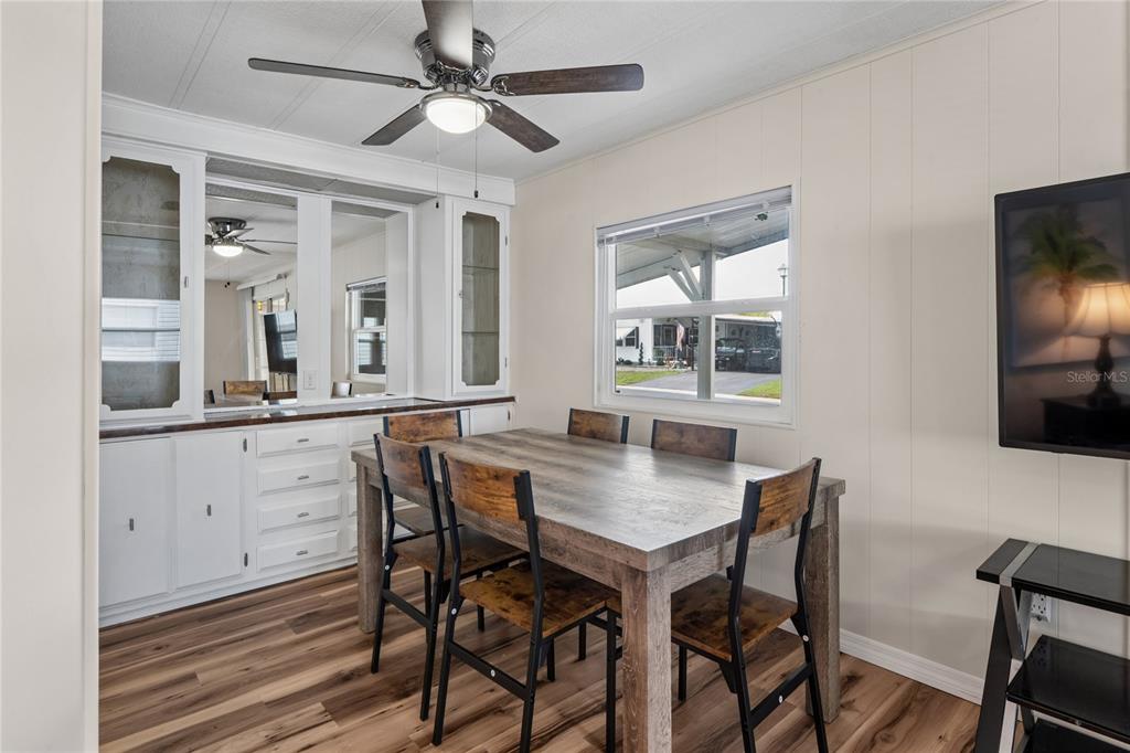 A dining room features a wooden table, chairs, white cabinetry, and a ceiling fan — 38552 MONET DRIVE, ZEPHYRHILLS, FL