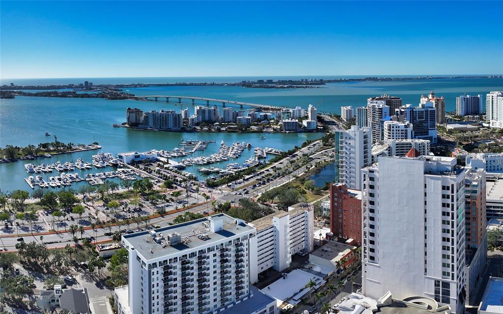 An aerial view of a coastal city featuring high-rise buildings, a marina, and a bridge — 33 S PALM AVENUE UNIT 1501, SARASOTA, FL